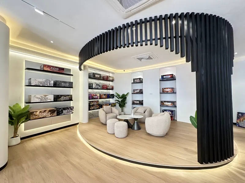 The HQ showroom seating area under a curved black slat ceiling, armchairs and stools around a low round table.