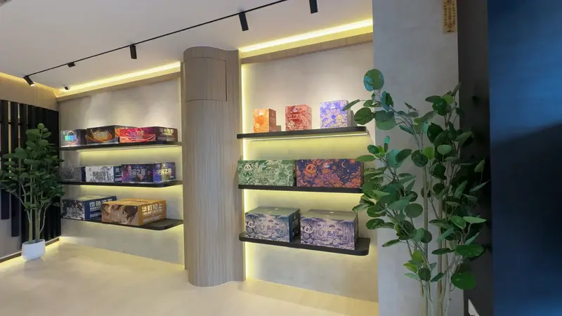 Shelving at Nilai around a column, printed cartons on every level with plants between them.
