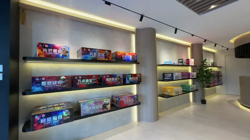 The full length of the Nilai floor: two lit shelf walls facing each other with the bench between them.