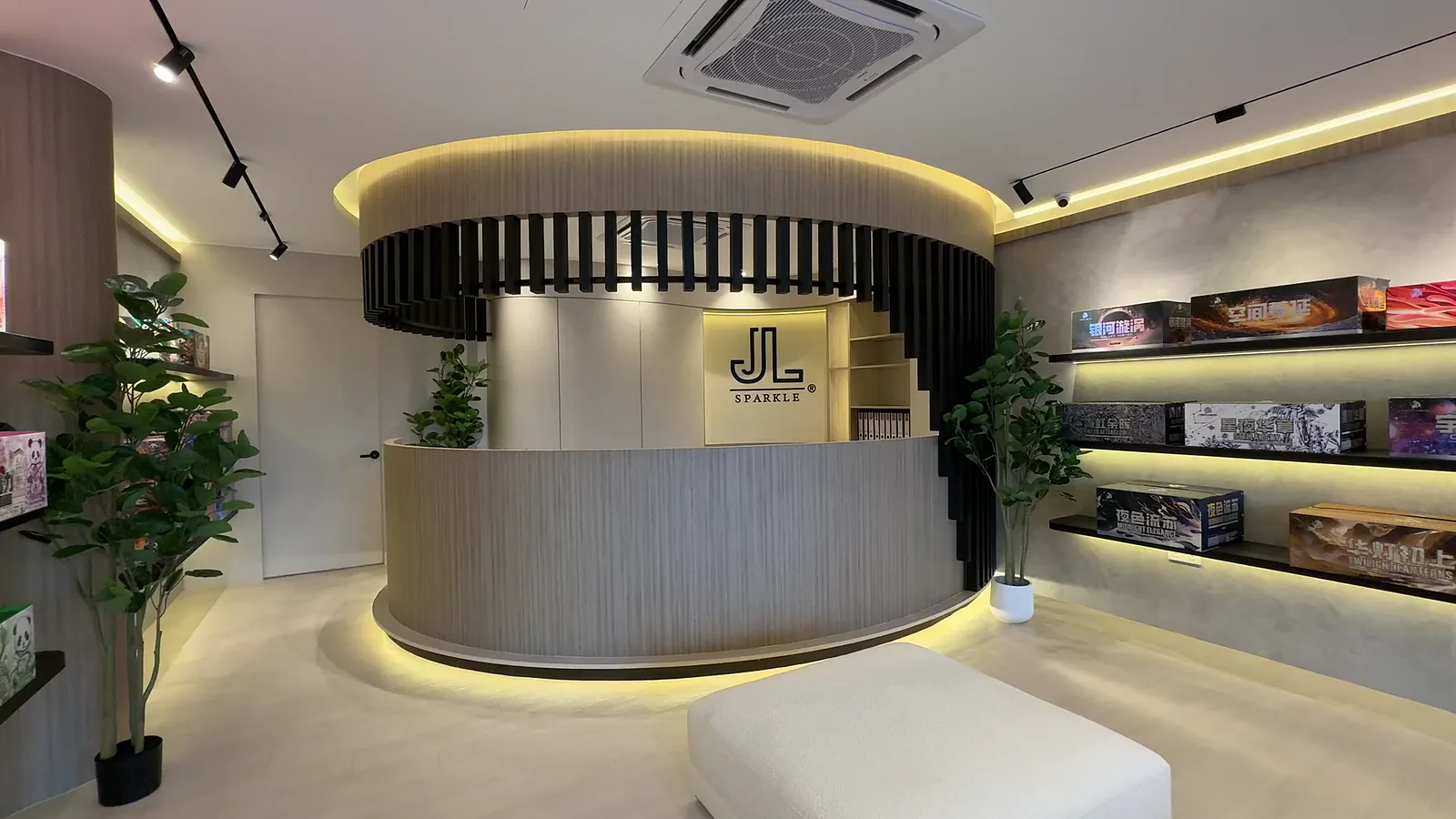 The Nilai showroom: its round counter with the lit JL SPARKLE mark on the wall behind, and shelves of boxed fireworks down the right-hand wall.